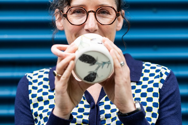 Marney McDiarmid holding one of her cups with a plant decal on the bottom.
