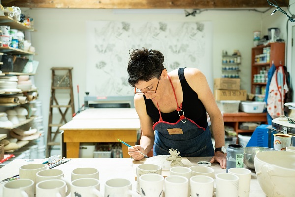 Marney McDiarmid paints ceramics in her studio.