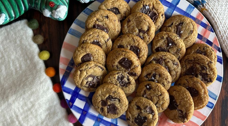  Olive Oil Chocolate Chip Cookies arranged on a plate next to an adorable stuffed animal, enhancing the warm atmosphere.