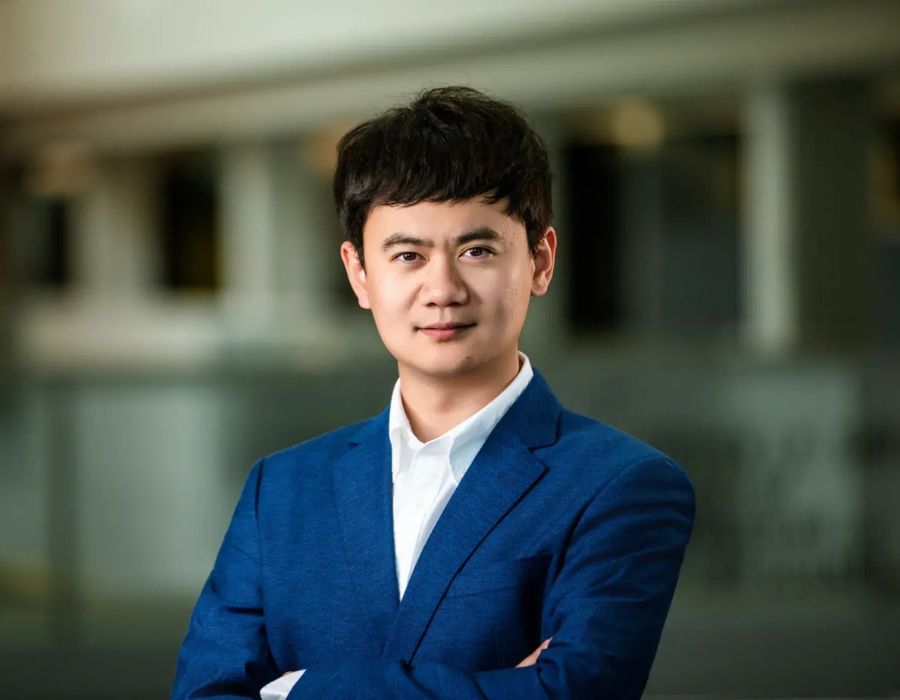 Doctor looking at the camera, wearing a professional attire, with a blurred background.