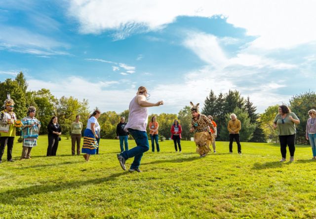 Participants from A Mile in Their Shoes outside in a dancing circle. 