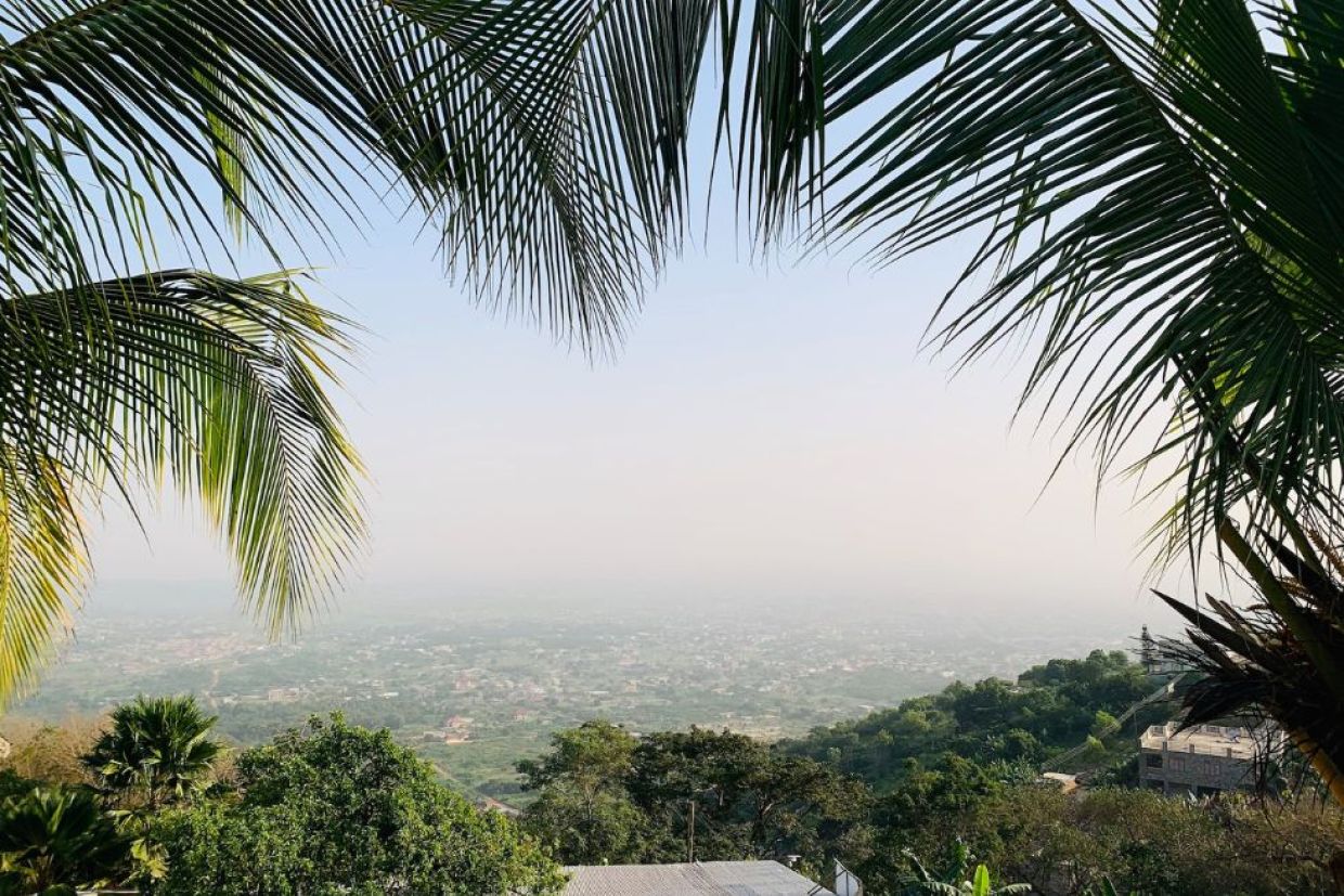 View framed by palm tree leaves of Peduase, Ghana.