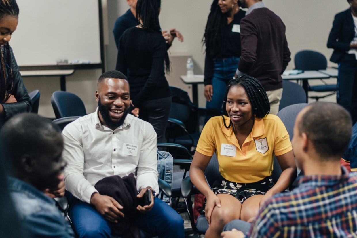 Members of QBAC sit together talking and smiling.