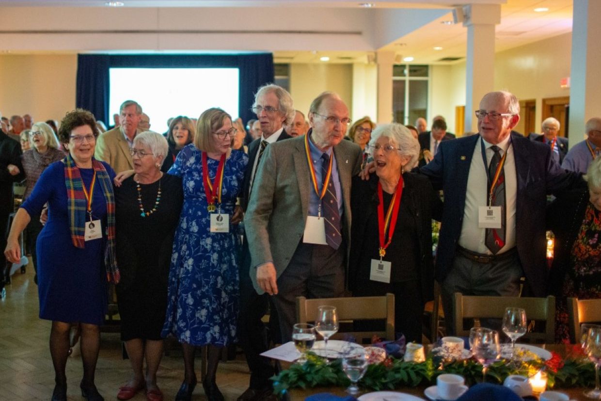 Tricolour Guard members stand in a line dancing to the Oil Thigh
