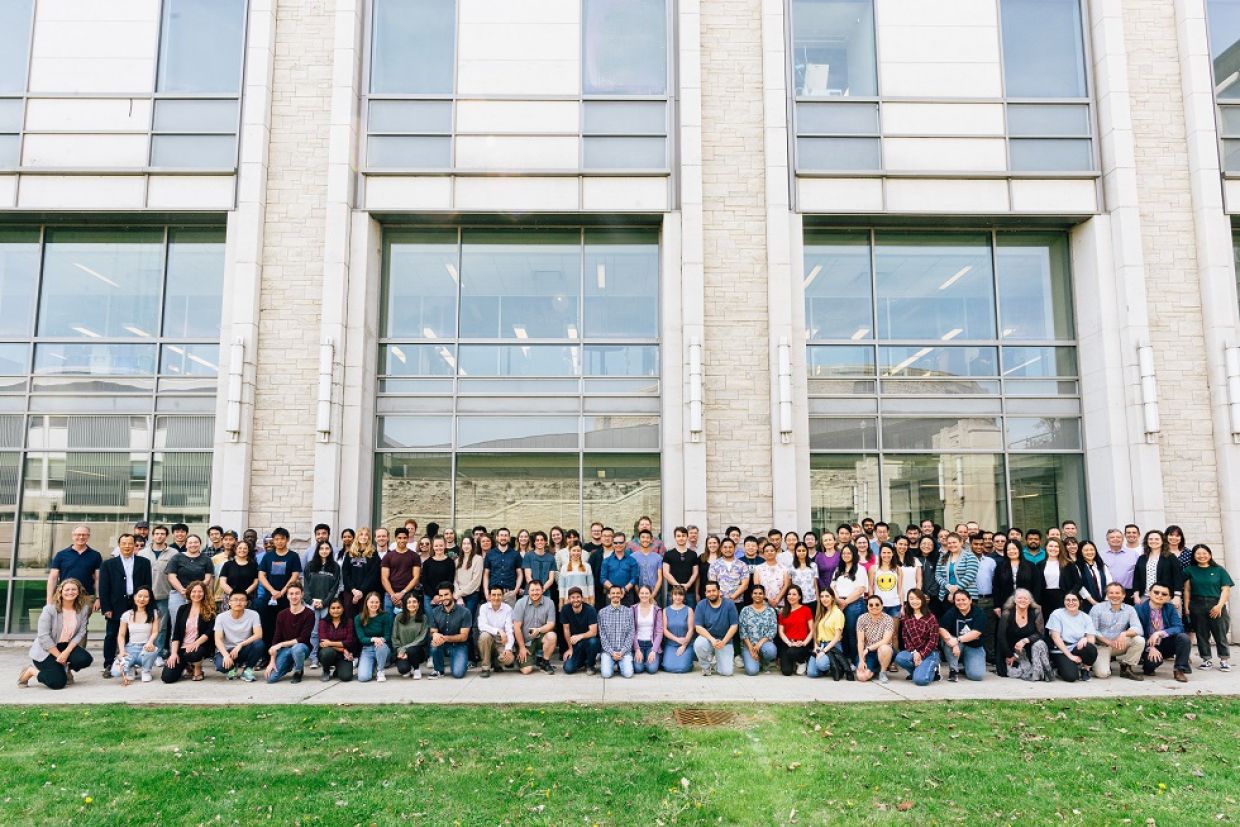 alumni pose in front of chemistry building