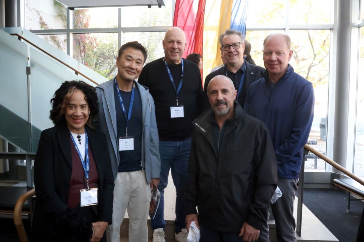 a group of alumni pose in the law building atrium
