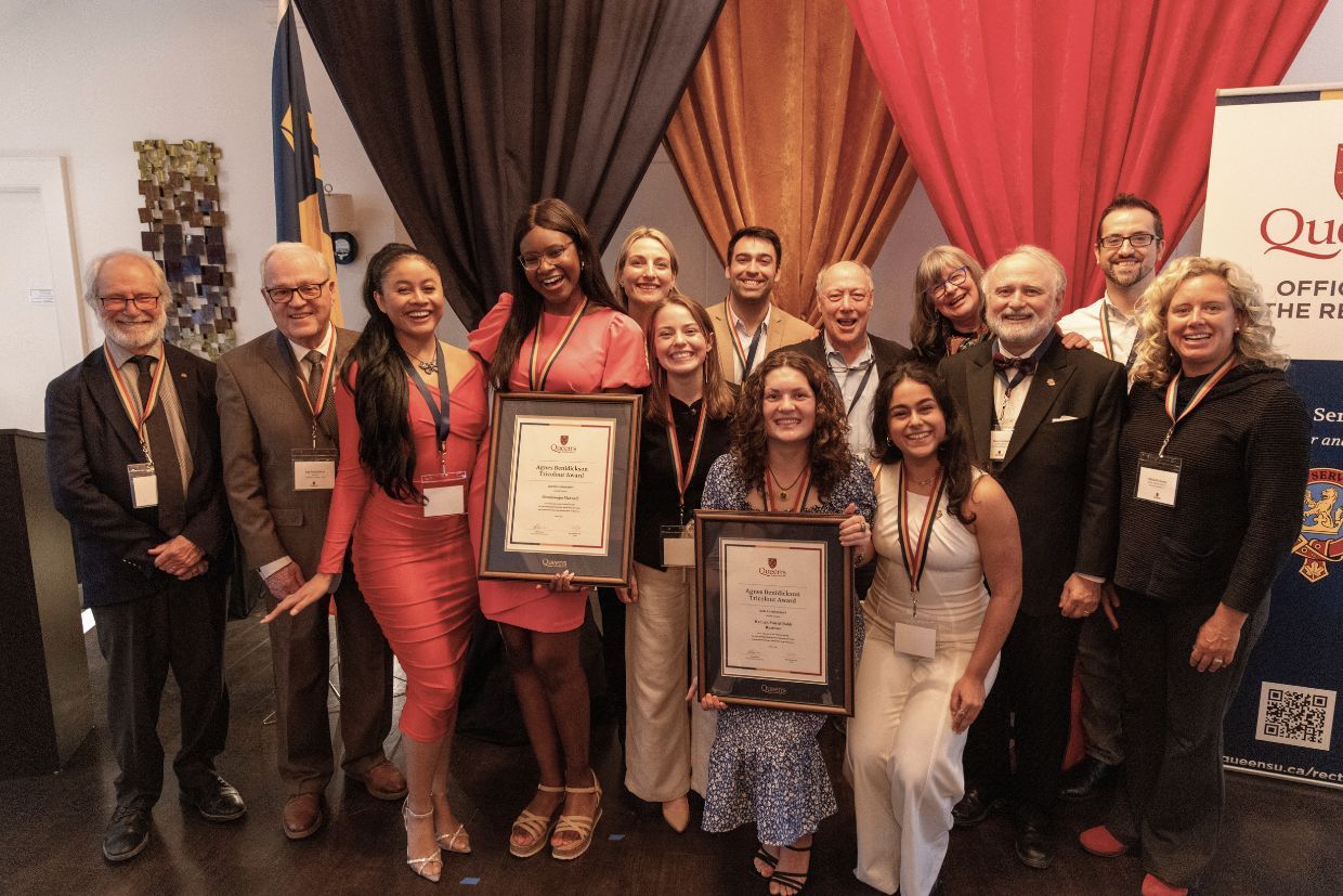 A group of students proudly holding their Agnes Benidickson Tricolour Awards at a conference, celebrating their achievements.
