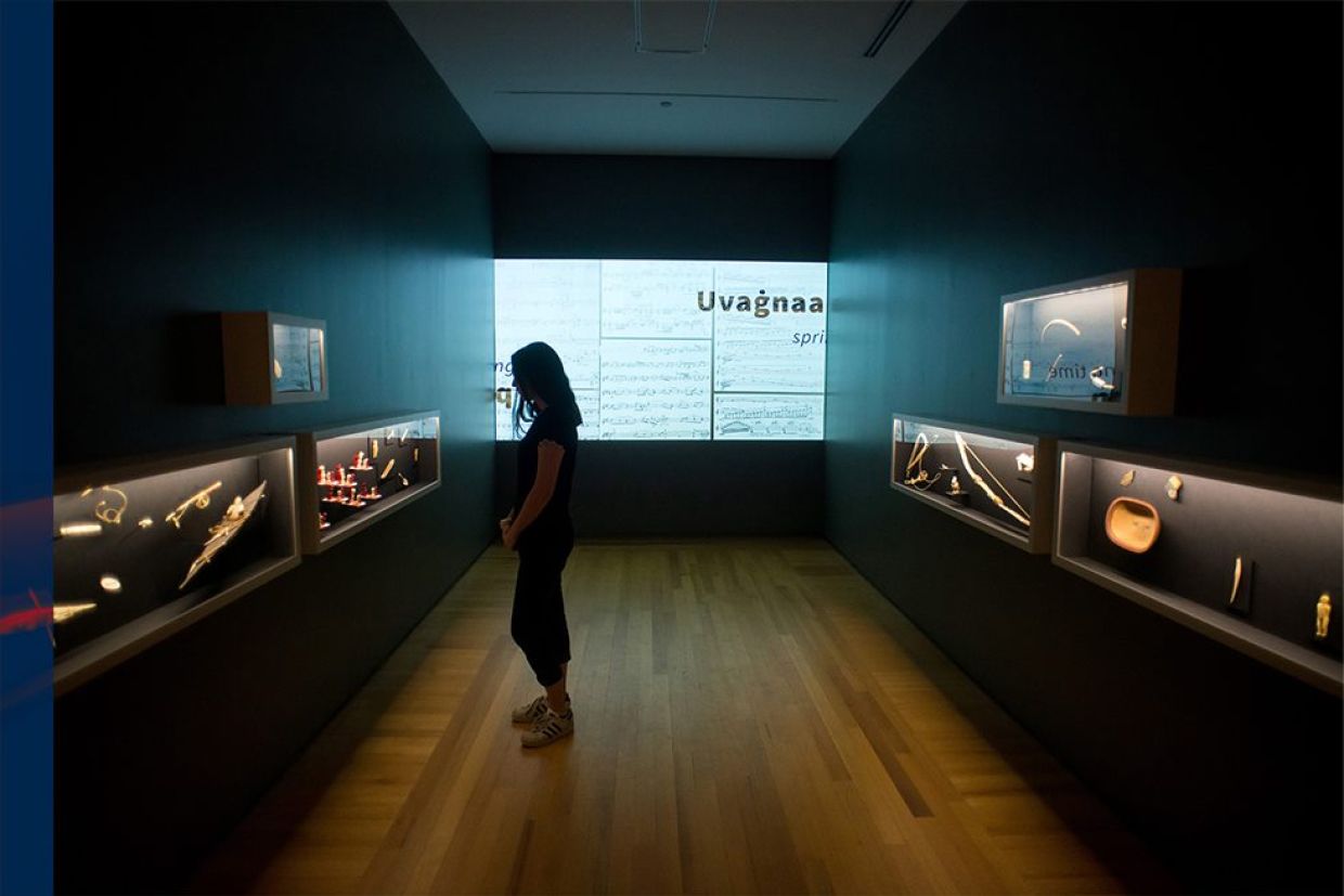 Woman standing viewing the Indigenous Art Collection at the Agnes Etherington Art Centre