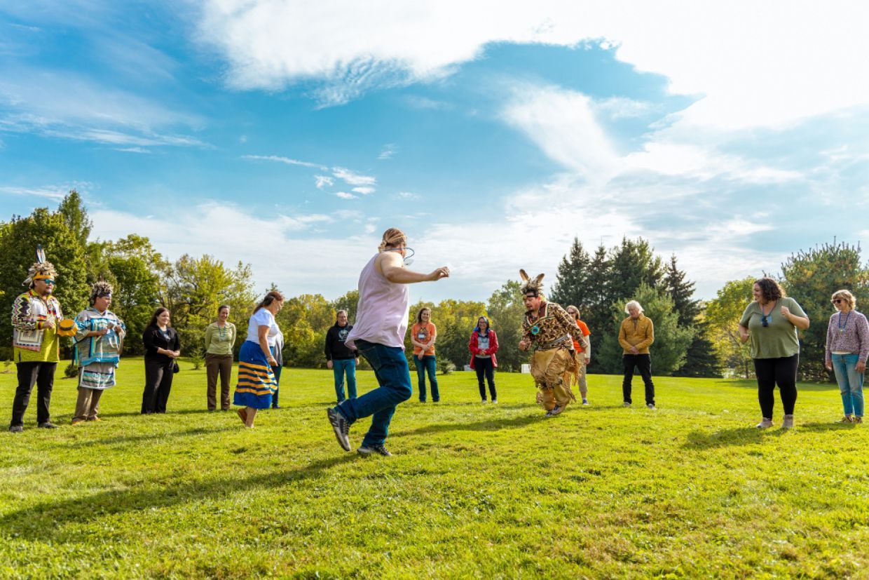 Participants from A Mile in Their Shoes outside in a dancing circle. 