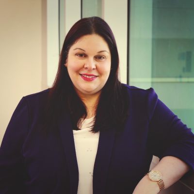 Cecilia Aparicio, Senior Gift Planning Officer at Queen's, wearing a formal attire and smiling. 