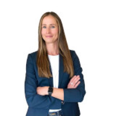 Carolyn smiling. She is wearing a white shirt and blue jacket 