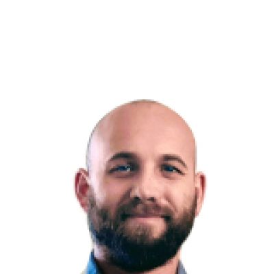 Simon smiling. He has a beard and is wearing a blue collared shirt 