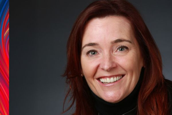 photo of Susanne Gage looking at the camera, smiling. Susanne is wearing a black shirt