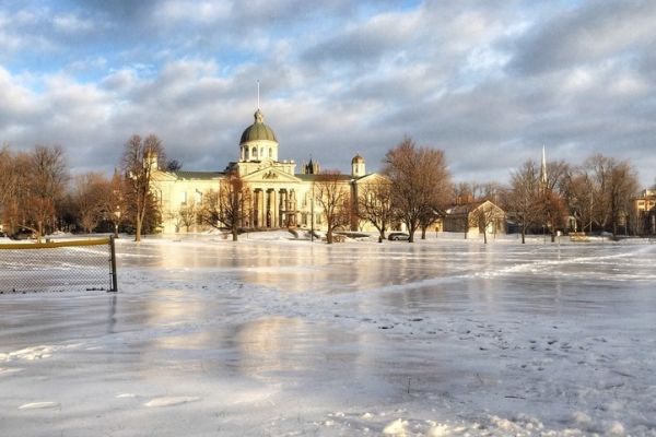 Photo of the Kingston City Hall during winter with sunlight across the frozen lake.