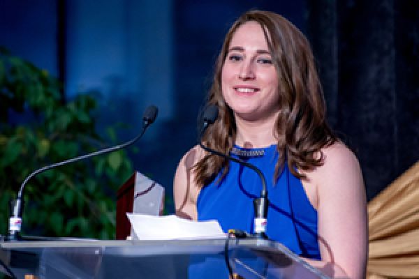 QUAA Awards Gala. Award recipient stands at podium.