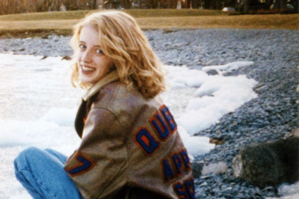 Michele Mainland wearing her Queen's Applied Science jacket on a beach 