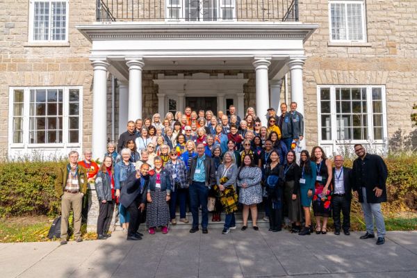 Students and alumni pose outside in front of the donald gordon conference centre