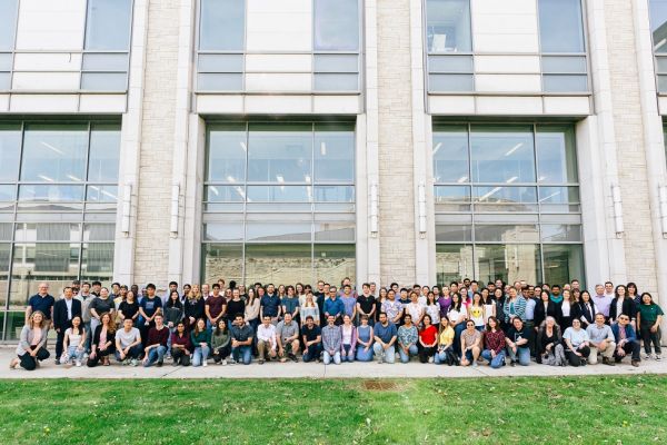 alumni pose in front of the chemistry building