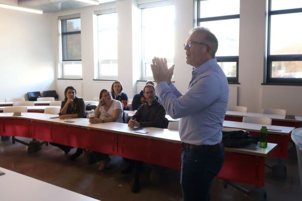 A professor gives a speech in front of seated audience
