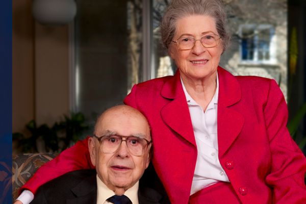 Alfred and Isabel Bader sit together on a chair.
