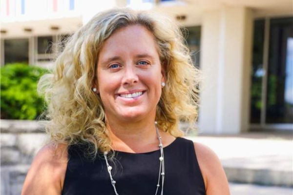 Dr. Michelle Searle smiling, wearing a black suit in an outdoor setting.
