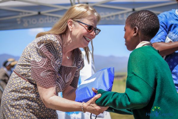 Peg Herbert shaking hands with a child