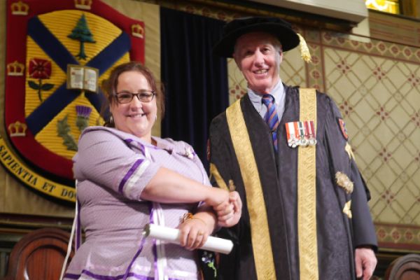 [Melanie Gray with Chancellor Jim Leech at Convocation]