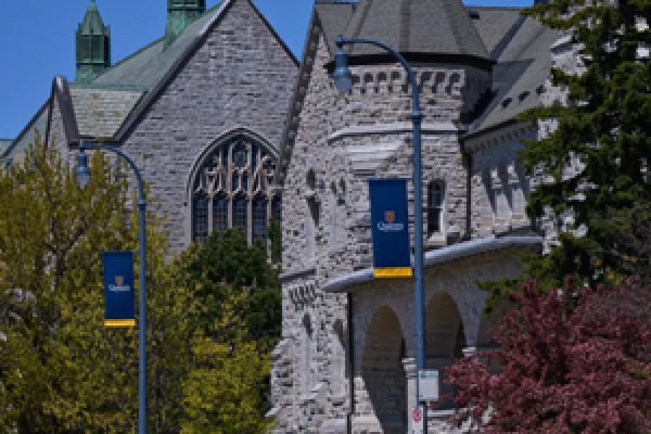 Queen's banner in front of campus buildings