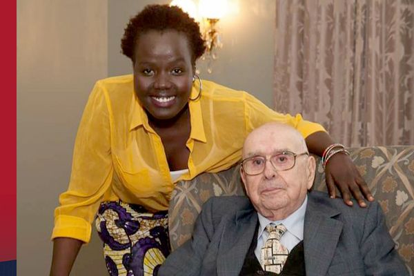 Alfred Bader sits in a chair looking pleased, while Solomon stands nearby smiling.
