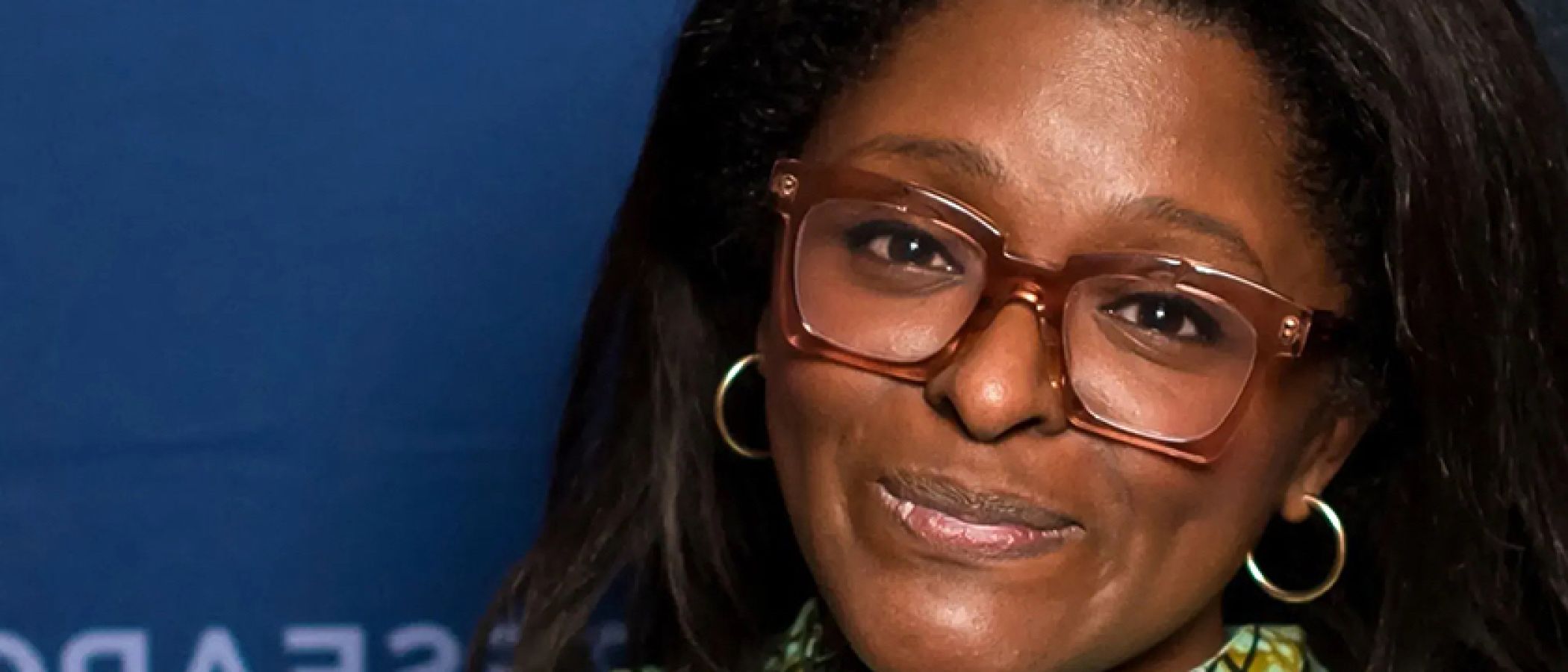 Dr. Kristin Moriah standing in front of a blue background.