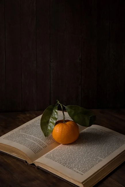 book a desk and an orange on the open book