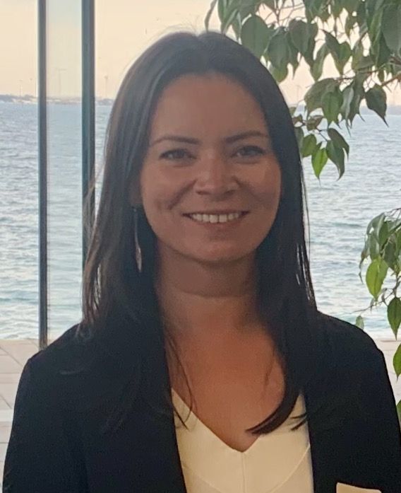 Photo of Tina posing with Lake Ontario in the background