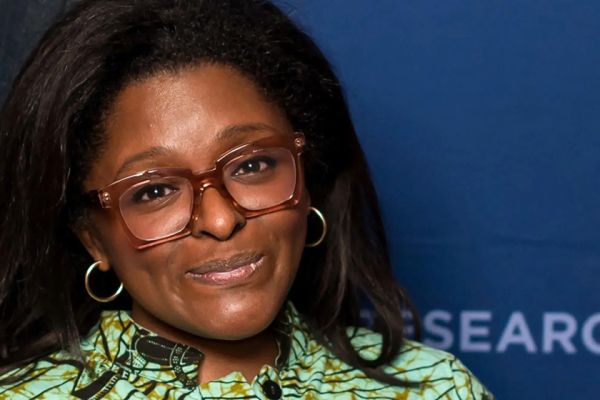 Dr. Kristin Moriah standing in front of a blue background.