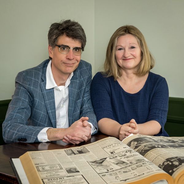 photo of Chris and Karen sitting at a table with a newspaper 
