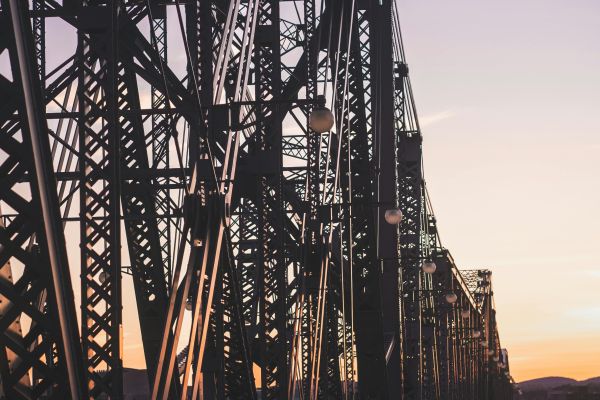 people walking on a bridge during sunset