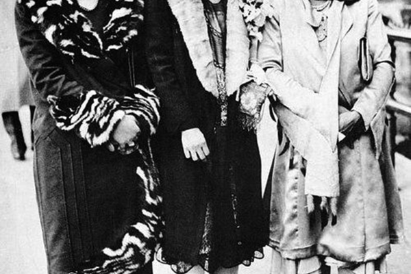 Three women posing in the middle of the street in black and white 
