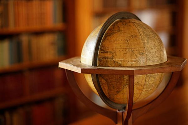 a wooden globe in a stand in a library