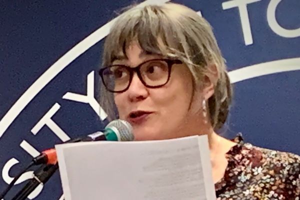 photo of heather reading at a podium 