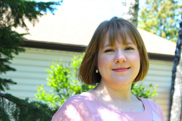 photo of Megan in front of trees and a building