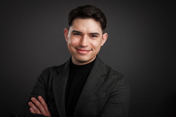 Headshot of Ian M. Clark wearing a grey suit against a dark background.