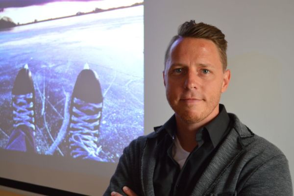 photo of sam in front of image of hockey states on ice