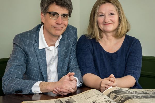 photo of Chris and Karen sitting at a table with a newspaper 