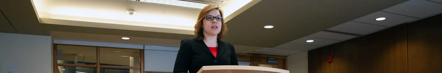 Photo of a person speaking in public during an event