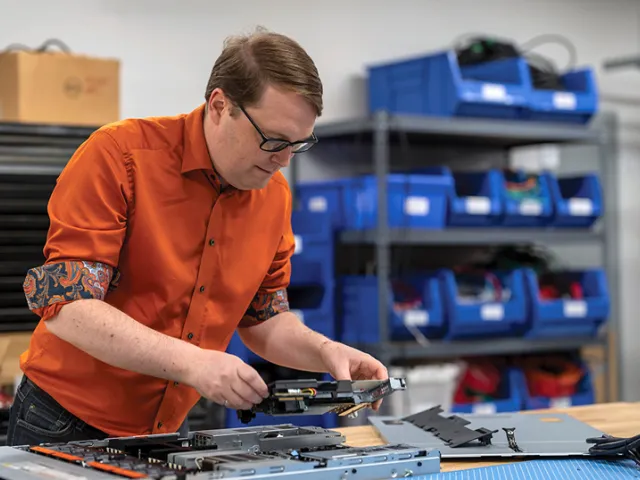 Photo of Dr. Ryan Grant assembling computer hardware at a workbench.